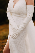 White dress with long gloves against a blurred natural background